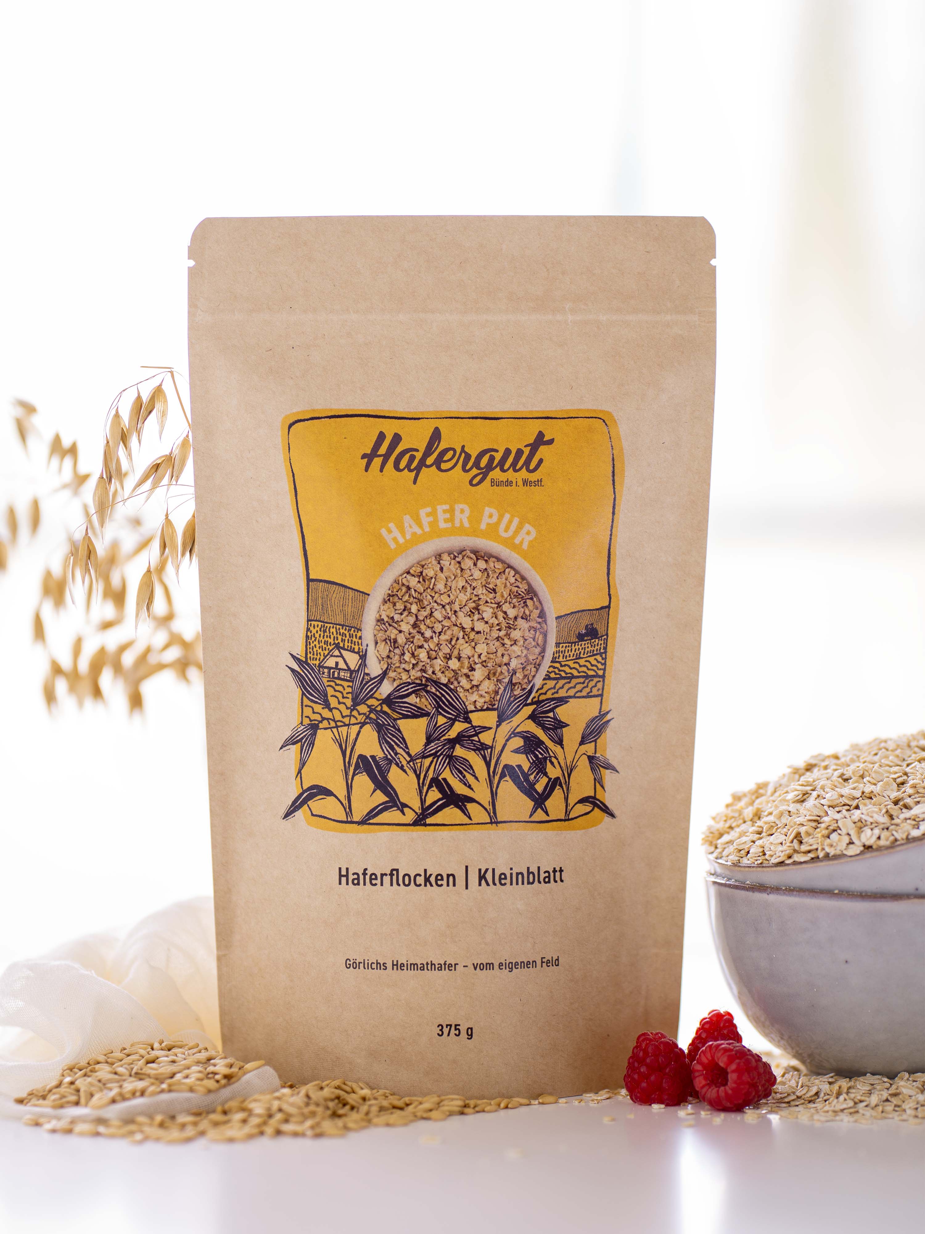 Zu sehen ist eine gefüllte Tüte mit Haferflocken. Es handelt sich dabei um ein Produktbild, welches das Produkt Haferflocken repräsentiert.