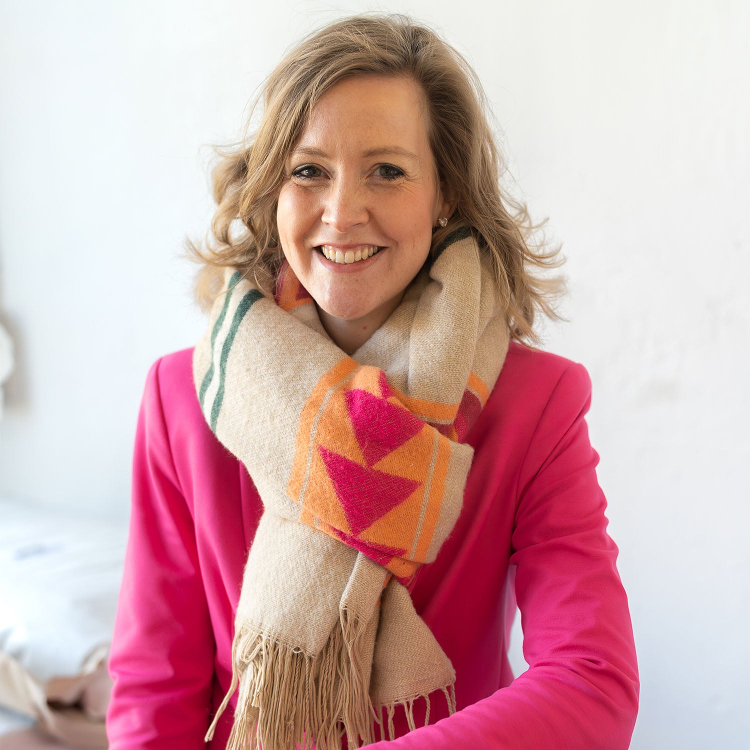 Gründerin Victoria strahlt mit ihrem Lächeln und überzeugt in einem pinkfarbenen Blazer. Das Portrait entstand in einer sehr hellen Halle, wo die Hafersäcke gelagert werden.